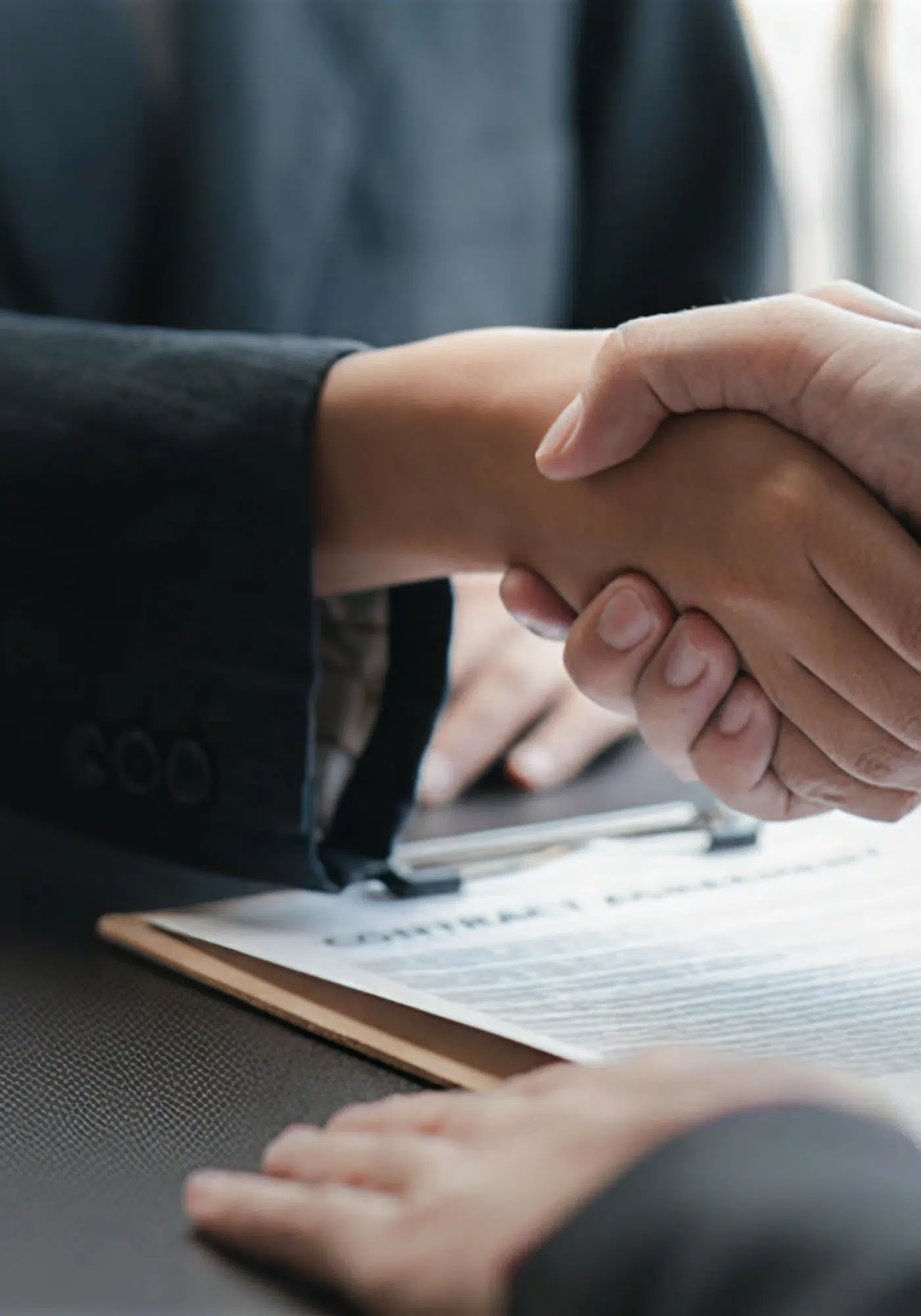 Poignée de main au-dessus d'un contrat | Cassius Avocats | Paris